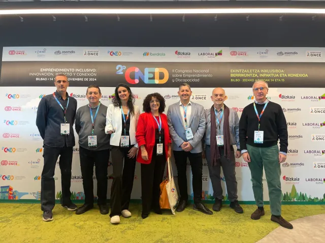 Un grupo de asistentes con acreditación posa ante el photocall del II CNED en Bilbao