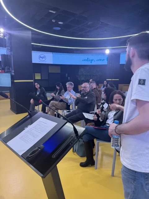 Un ponente se dirige al público junto al atril en la sala del HUB Por Talento Digital