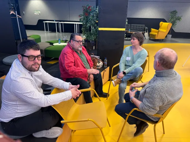 Cuatro asistentes conversan sentados en corro durante el tiempo de networking